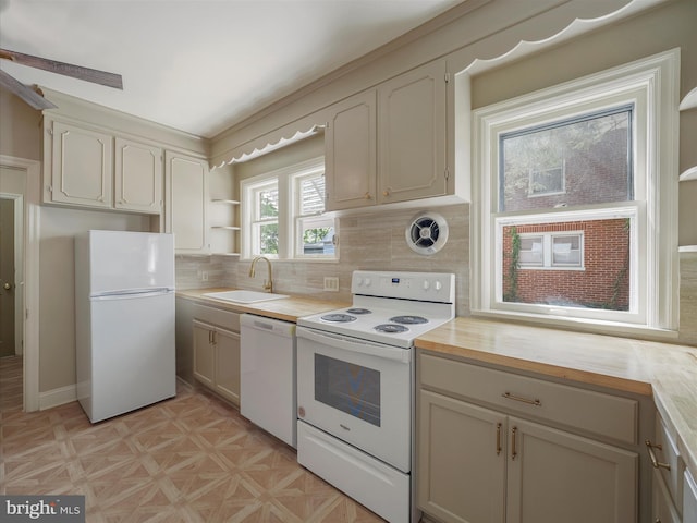 kitchen featuring white appliances, light parquet flooring, tasteful backsplash, and sink