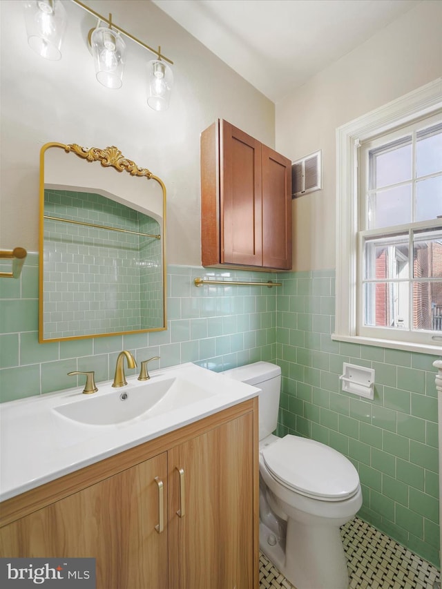 bathroom featuring vanity, tile walls, toilet, and tile patterned floors