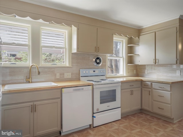 kitchen featuring white appliances, tasteful backsplash, a healthy amount of sunlight, and sink