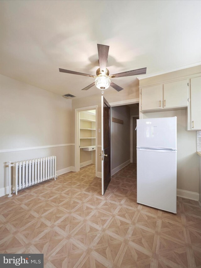 kitchen with radiator, white refrigerator, light parquet floors, and ceiling fan