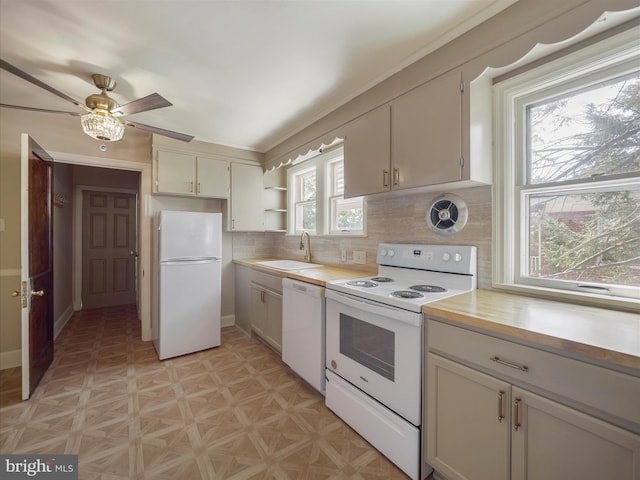 kitchen with white appliances, ceiling fan, plenty of natural light, and sink