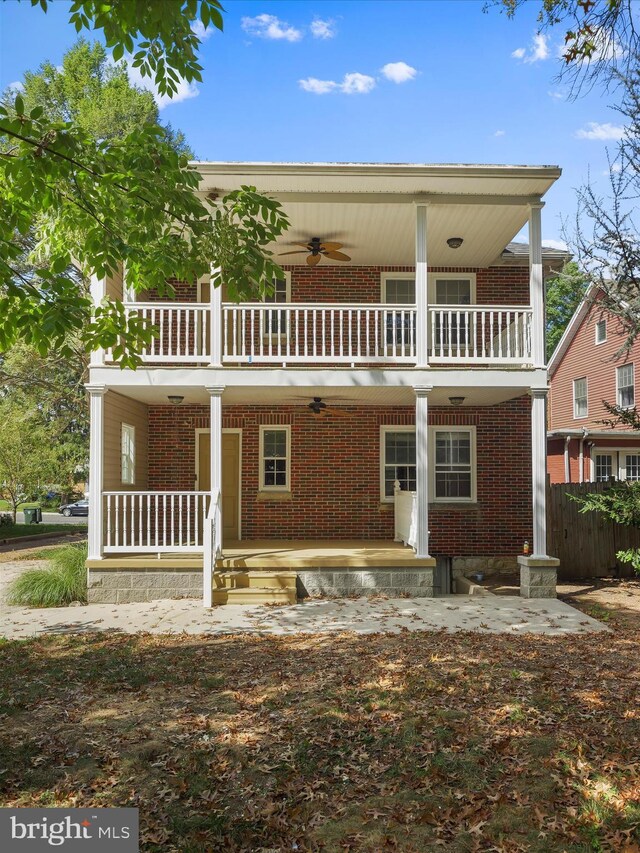 rear view of property with a balcony, ceiling fan, and covered porch