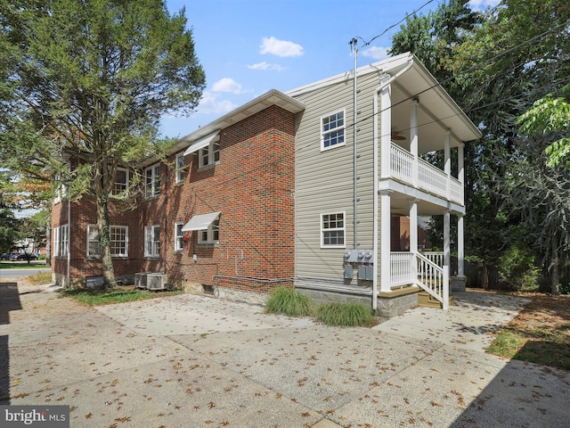 view of home's exterior with a balcony, covered porch, and central AC unit