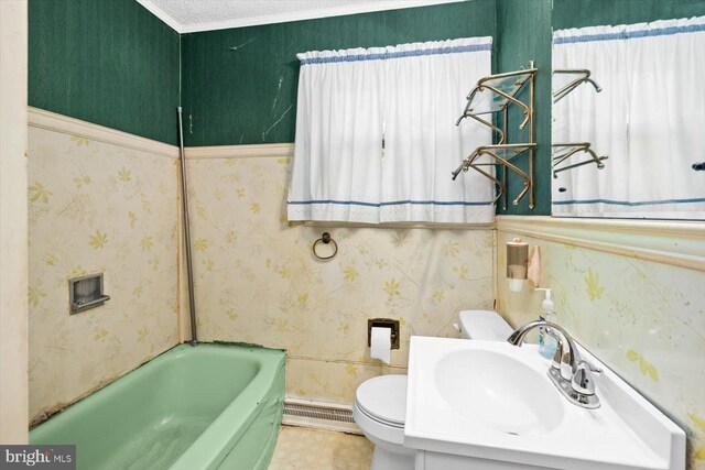 bathroom with a baseboard radiator, a bath, vanity, and toilet