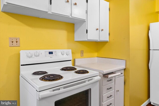 kitchen featuring white cabinets and white appliances