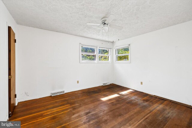 spare room featuring ceiling fan, a textured ceiling, and dark hardwood / wood-style flooring