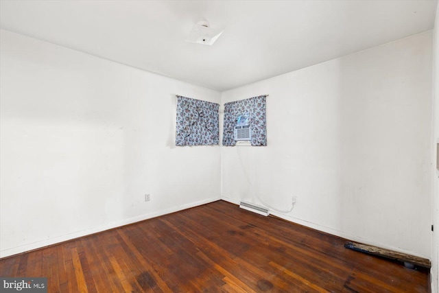 spare room with cooling unit and dark hardwood / wood-style flooring