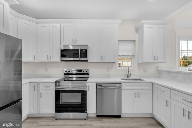 kitchen featuring appliances with stainless steel finishes, white cabinetry, and a healthy amount of sunlight