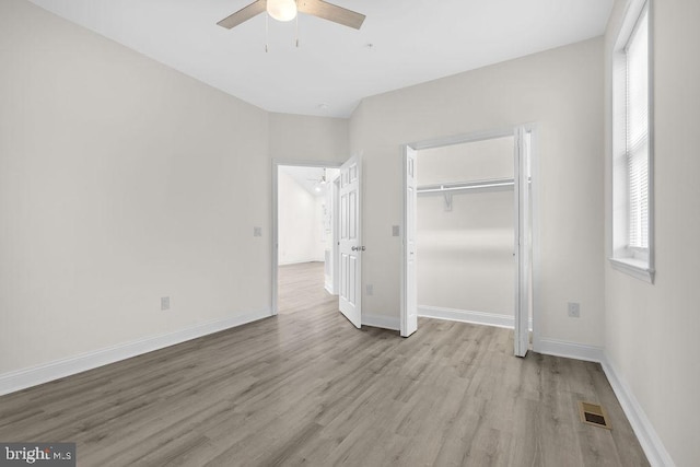 unfurnished bedroom with multiple windows, ceiling fan, a closet, and light hardwood / wood-style floors