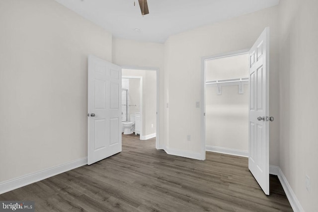 unfurnished bedroom with ceiling fan, dark wood-type flooring, and a closet