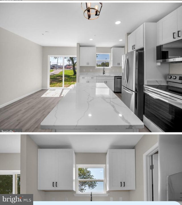 kitchen with white cabinets, appliances with stainless steel finishes, light stone counters, and a wealth of natural light