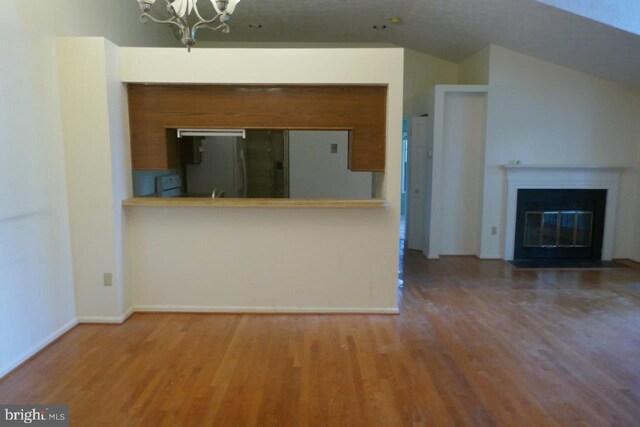 kitchen with a notable chandelier, fridge, and hardwood / wood-style floors