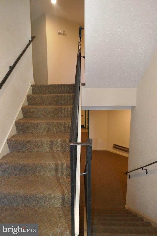 stairs with vaulted ceiling, a textured ceiling, and carpet flooring