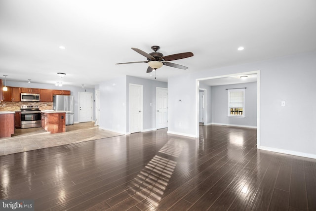 unfurnished living room featuring hardwood / wood-style floors and ceiling fan