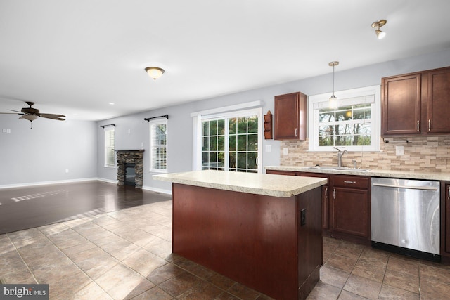 kitchen with a center island, dishwasher, decorative backsplash, sink, and decorative light fixtures