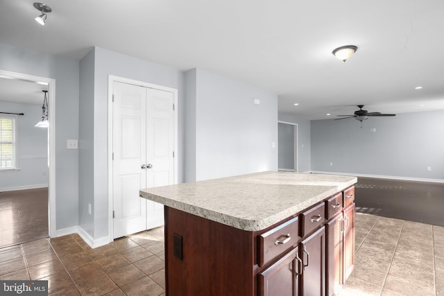 kitchen featuring ceiling fan, tile patterned floors, and a kitchen island