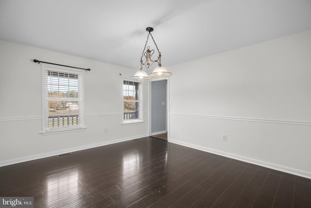 unfurnished room featuring dark hardwood / wood-style floors and a chandelier