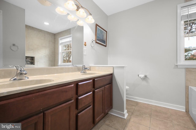 bathroom with vanity, tile patterned floors, toilet, and a bathtub