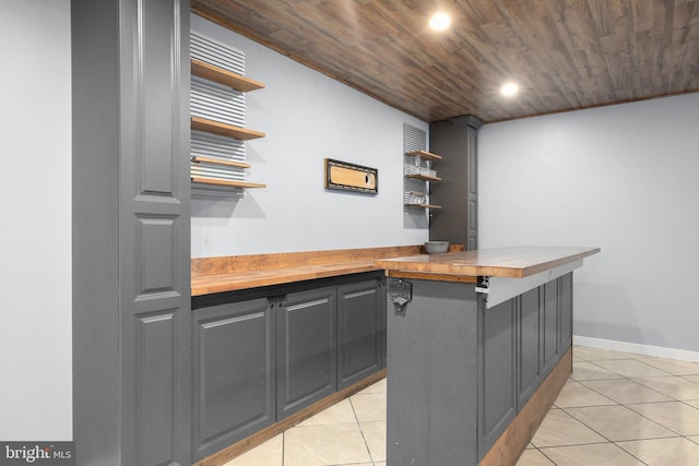 bar featuring wooden ceiling, wood counters, and light tile patterned floors