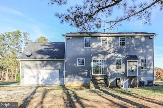 back of property featuring a garage and a yard