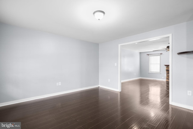 spare room with dark wood-type flooring and ceiling fan