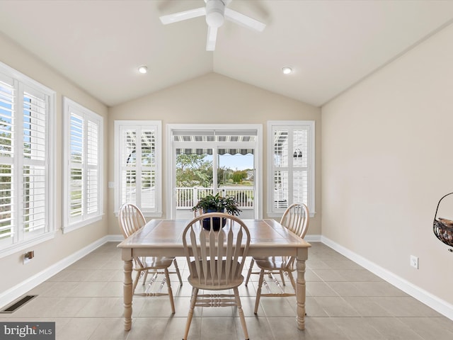 dining space with a wealth of natural light, vaulted ceiling, ceiling fan, and light tile patterned flooring