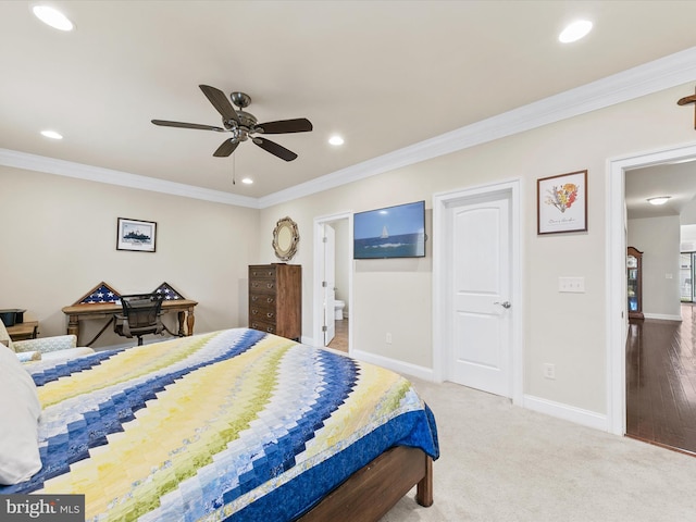 bedroom featuring ceiling fan, carpet floors, ensuite bath, and ornamental molding