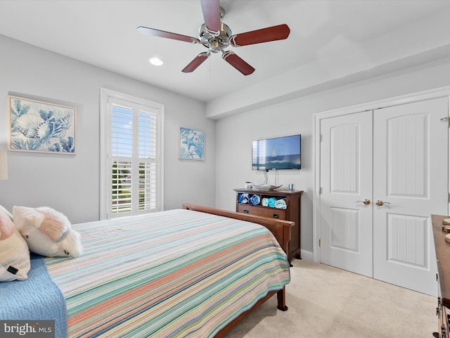 carpeted bedroom featuring ceiling fan and a closet