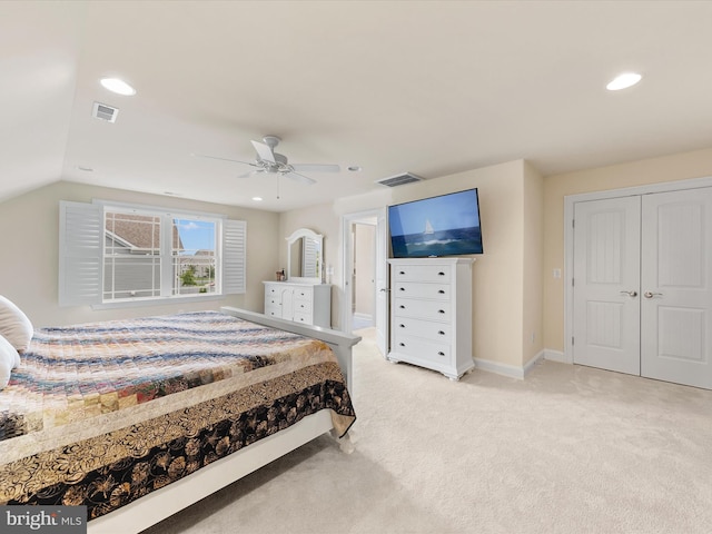 bedroom featuring a closet, vaulted ceiling, ceiling fan, and light colored carpet