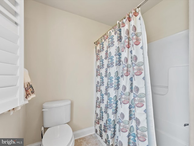 bathroom with curtained shower, tile patterned flooring, and toilet