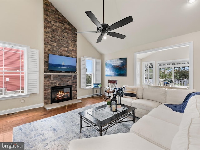 living room with a wealth of natural light, ceiling fan, wood-type flooring, and a fireplace