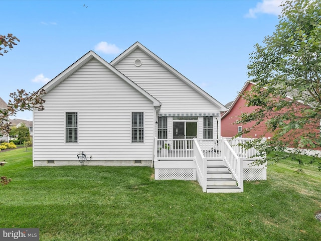 rear view of house featuring a deck and a yard