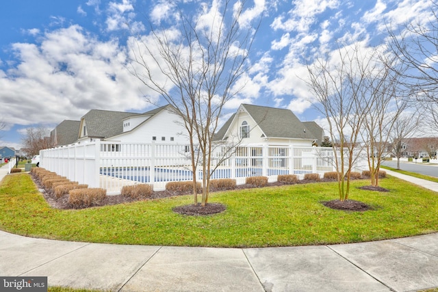 view of property exterior featuring a covered pool and a lawn