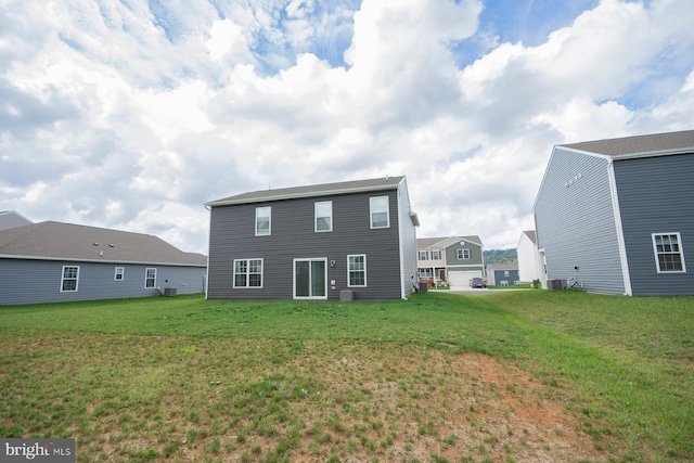 back of house with a lawn and central air condition unit