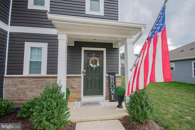 property entrance featuring a lawn