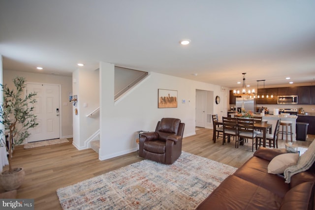 living room featuring light wood-type flooring and an inviting chandelier