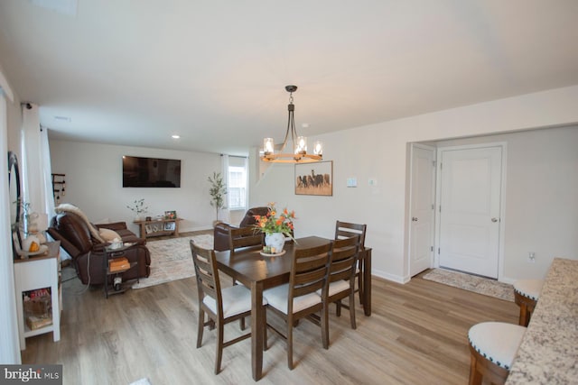 dining area with an inviting chandelier and light hardwood / wood-style floors