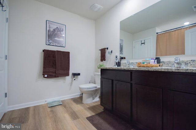 bathroom with vanity, hardwood / wood-style floors, and toilet