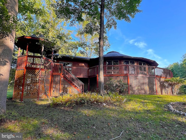 back of property featuring a lawn, stairs, and a deck