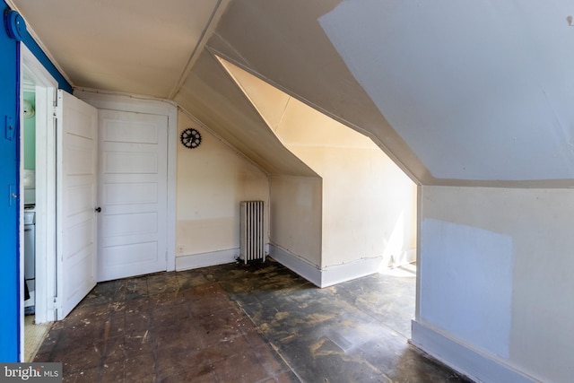 additional living space featuring radiator heating unit and vaulted ceiling