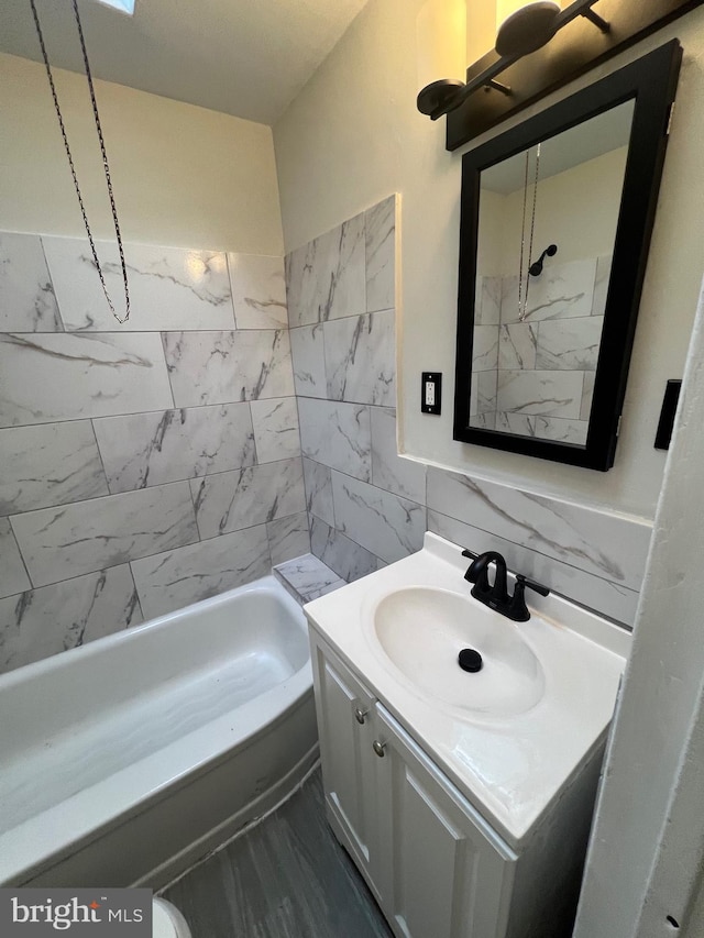 bathroom with tiled shower / bath, tile walls, and vanity