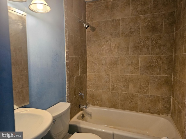 full bathroom with toilet, tiled shower / bath, and sink