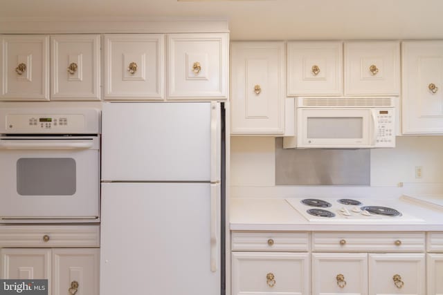 kitchen with white cabinetry and white appliances