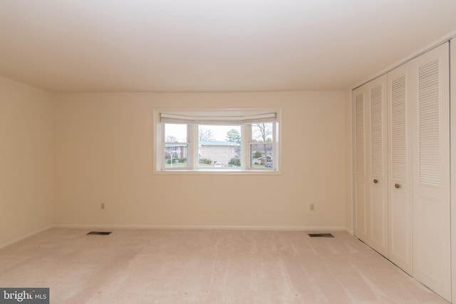 unfurnished bedroom featuring light carpet