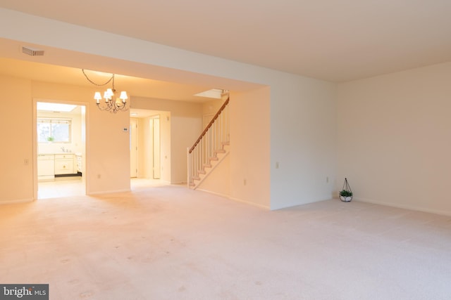 empty room featuring light carpet and an inviting chandelier