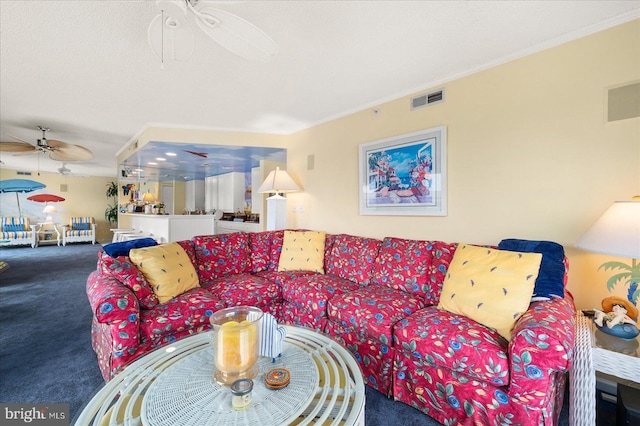 carpeted living room featuring ceiling fan, a textured ceiling, and ornamental molding