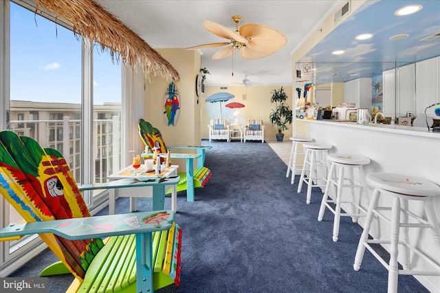 interior space featuring ceiling fan and dark carpet