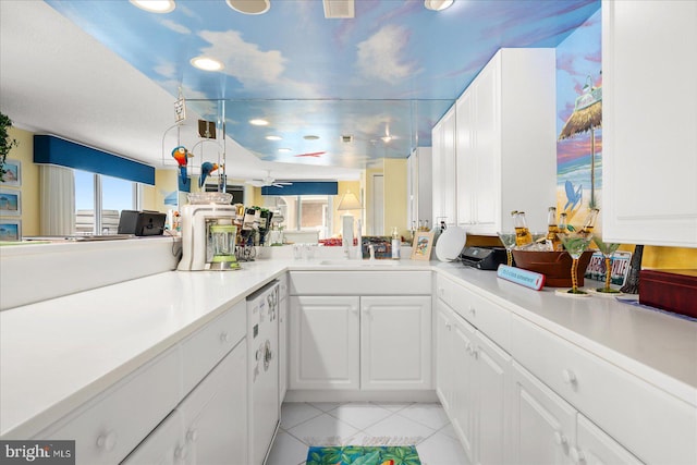 kitchen featuring white cabinets, sink, light tile patterned floors, kitchen peninsula, and dishwasher