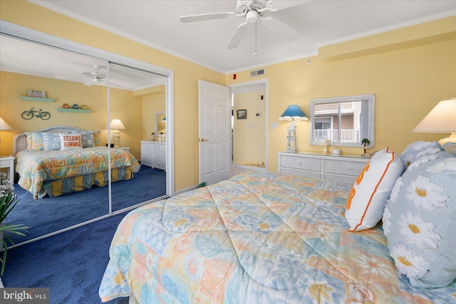 carpeted bedroom featuring a textured ceiling, ornamental molding, ceiling fan, and a closet