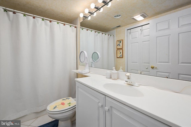 bathroom with tile patterned flooring, a textured ceiling, vanity, and toilet